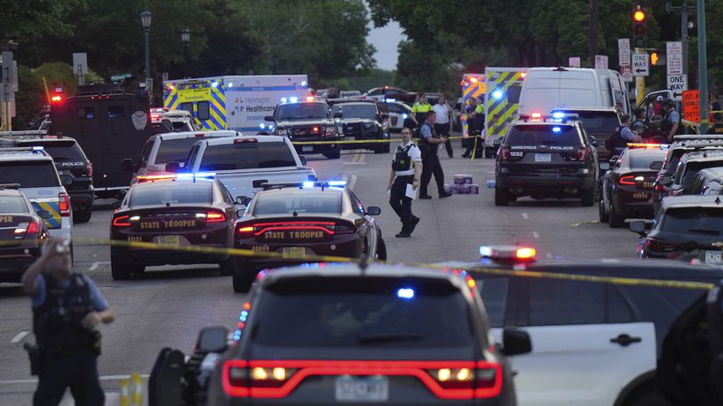 Investigators examine the scene of a shooting Thursday, May 30, 2024, in Minneapolis. Two Minneapolis police officers and four civilians were injured in south Minneapolis, Thursday in what officials are calling an active-shooter situation, law enforcement said. (Glen Stubbe/Star Tribune via AP)