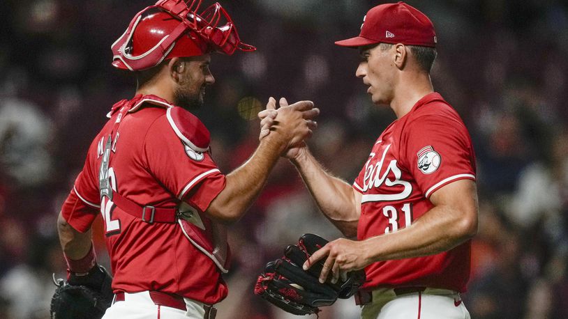 Cincinnati Reds pitcher Brent Suter (31) and catcher Luke Maile (22) celebrate after winning a baseball game against the Houston Astros, ,Wednesday, Sept. 4, 2024, in Cincinnati. (AP Photo/Carolyn Kaster)