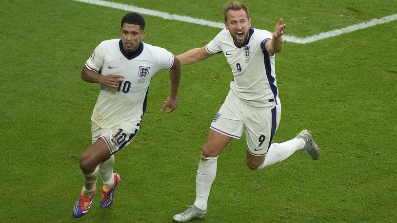 England's Jude Bellingham, left, celebrates with Harry Kane after scoring his side's first goal during a round of sixteen match between England and Slovakia at the Euro 2024 soccer tournament in Gelsenkirchen, Germany, Sunday, June 30, 2024. (AP Photo/Ebrahim Noroozi)