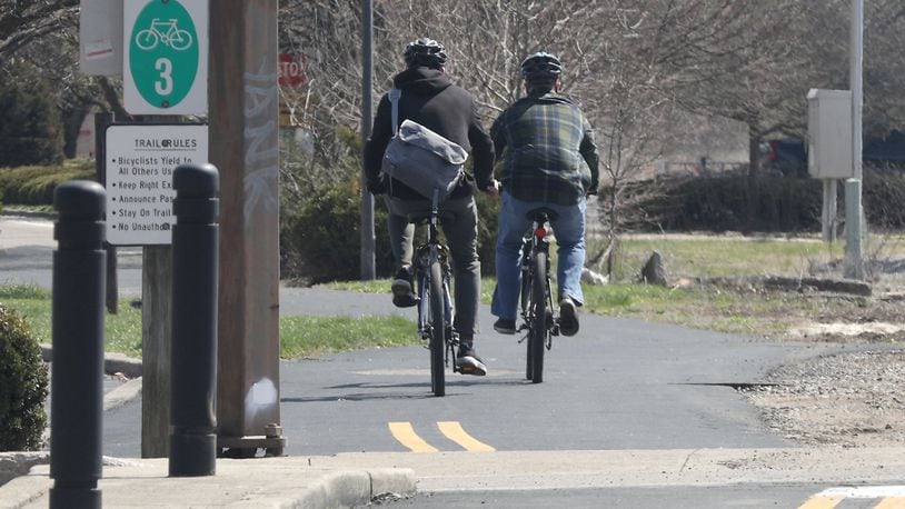 Cyclists ride along the Simon Kenton Bike Trail by the Clark County Heritage Center earlier this year. BILL LACKEY/STAFF