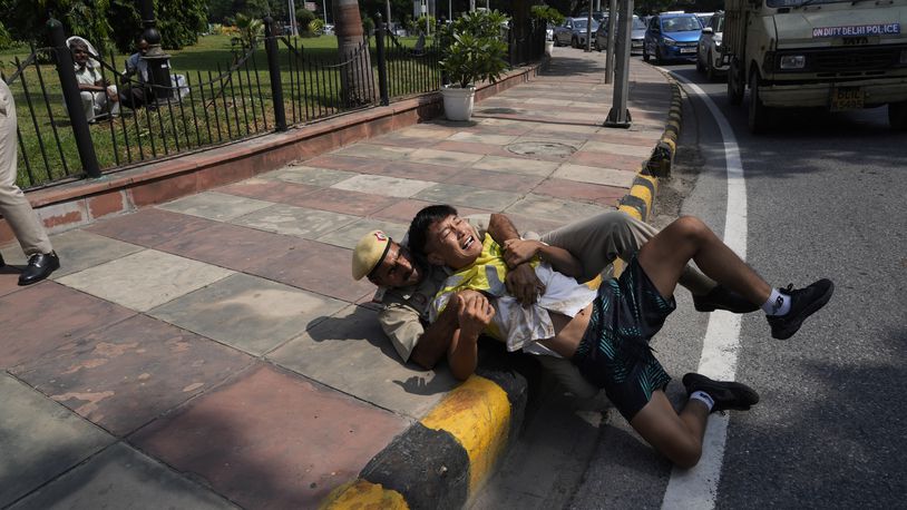 An Indian policeman detains an exile Tibetan protesting against the human rights situation in Tibet during a protest to coincide China marking its 75th year of Communist Party rule, outside Chinese embassy, in New Delhi, India, Tuesday, Oct. 1, 2024. (AP Photo/Manish Swarup)