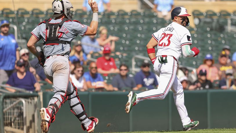 Minnesota Twins' Royce Lewis (23) is chased in a rundown by Cincinnati Reds catcher Tyler Stephenson, left, in the fourth inning of a baseball game Sunday, Sept. 15, 2024, in Minneapolis. (AP Photo/Bailey Hillesheim)