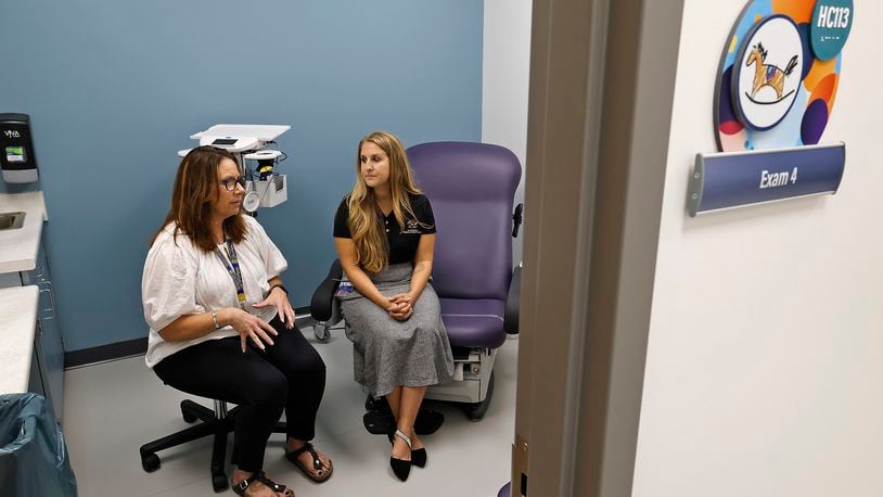 Anita Biles, from Springfield City Schools, left, and Amanda Ambrosio, from the Rocking Horse Center, discuss the success of The Health Center at Springfield High School Thursday, Sept. 26, 2024. While the center has only been open for a few weeks, they have already seen over 100 patients. BILL LACKEY/STAFF