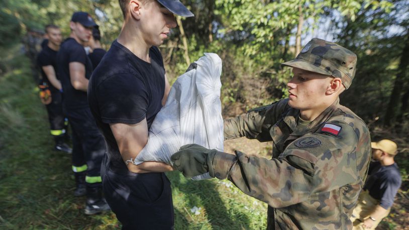 Soldiers fill and arrange sandbags to help strengthen the embankments and to prevent flooding near the city of Wroclaw, southwestern Poland, Tuesday, Sept. 17, 2024. (AP Photo/Krzysztof Zatycki)