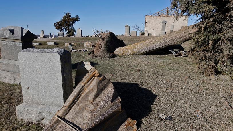 Grave markers and trees are toppled over in the Fletcher-Chapel Cemetery after Wednesday's tornado. BILL LACKEY/STAFF