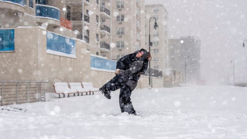 A father and son play in a snow storm in Long Beach, N.Y., Jan. 29, 2022. (Johnny Milano/The New York Times)