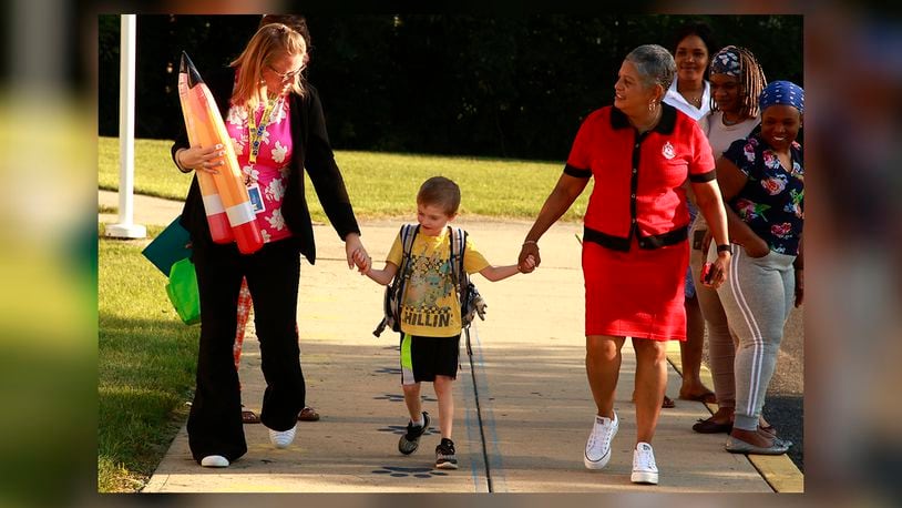 A student holds hands with the staff at Fulton Elementary as they walk into school for the first day Wednesday, August 14, 2024. BILL LACKEY/STAFF