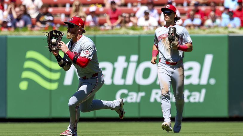 Cincinnati Reds right fielder Jake Fraley, left, catches a fly ball for an out against St. Louis Cardinals' Paul Goldschmidt during the fifth inning of a baseball game Sunday, June 30, 2024, in St. Louis. (AP Photo/Scott Kane)