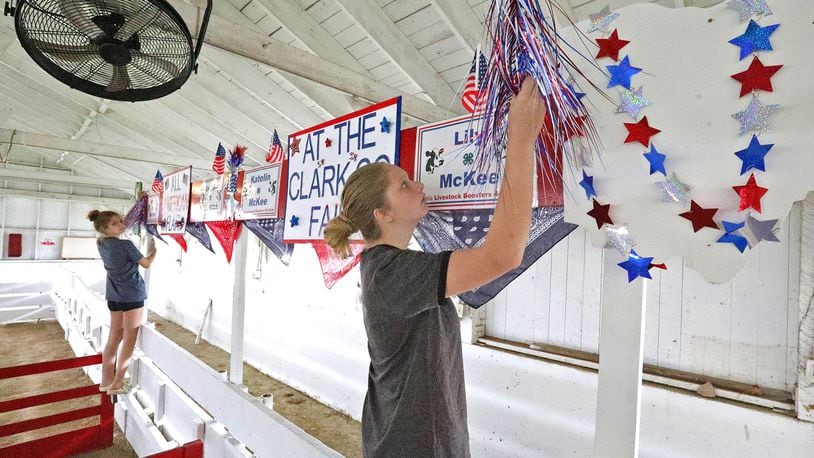 Katelin McKee, right, and her sister, Lily, decorate the pins for their cows Wednesday as they prepare for the opening of the Clark County Fair on Friday. BILL LACKEY/STAFF