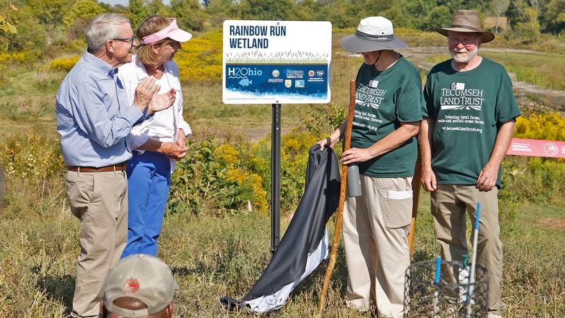 Gov. Mike DeWine and his wife, Fran, along Susan and Tom Miller unveil the sign for the new H2Ohio Rainbow Run Wetland on Old Clifton Road in Clark County Wednesday, Sept. 11, 2024. Tom and Susan Miller are the couple that donated the land for the wetland. BILL LACKEY/STAFF