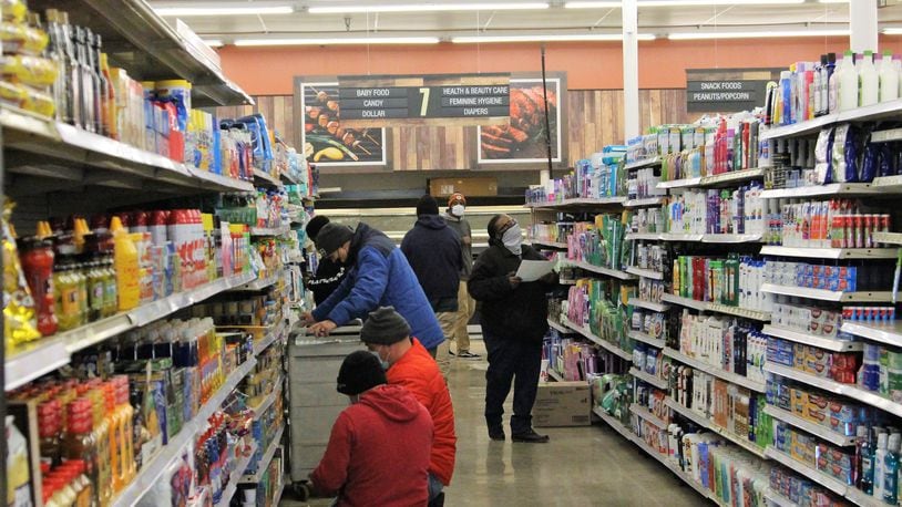 Cashiers and other employees at Groceryland prepare the store on Wednesday for its opening the following day. The grocery is located at the former Kroger building on South Limestone Street. Hasan Karim/Staff