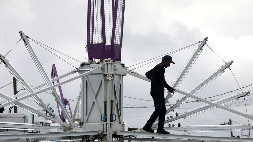 A Durant Amusements employee sets up a ride on the midway at the Clark County Fair Monday, July 19, 2022. BILL LACKEY/STAFF