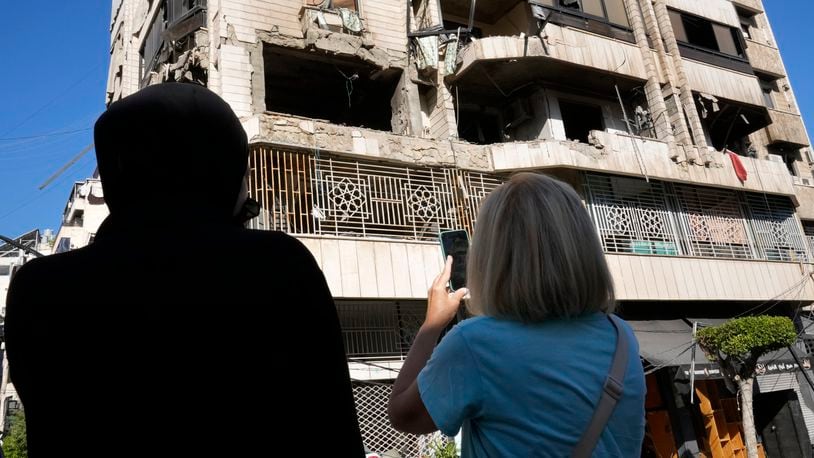 Lebanese women stand in front an apartment in a multistory building hit by Israeli airstrike, in central Beirut, Lebanon, Thursday, Oct. 3, 2024. (AP Photo/Hussein Malla)