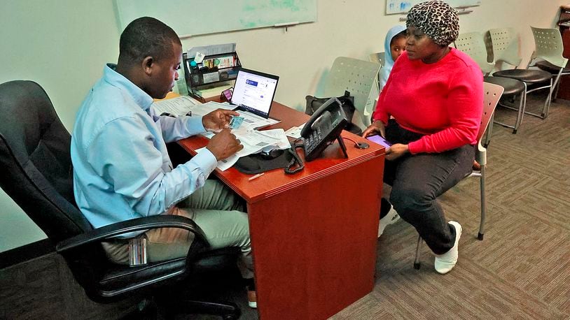 Lormilia Laguerre, an immigrant from Haiti, visits Johnson Salomon, an interpreter at the Rocking Horse Center, for help with immigration paperwork she received Wednesday, May 3, 2023 as her daughter, Snica, waits in the background. BILL LACKEY/STAFF