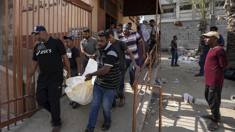 Mourners carry the covered bodies of Palestinians who were killed in an Israeli airstrike on a crowded tent camp housing Palestinians displaced by the war in the Muwasi, outside the hospital morgue in Deir al-Balah, Gaza Strip, Tuesday, Sept. 10, 2024. (AP Photo/Abdel Kareem Hana)