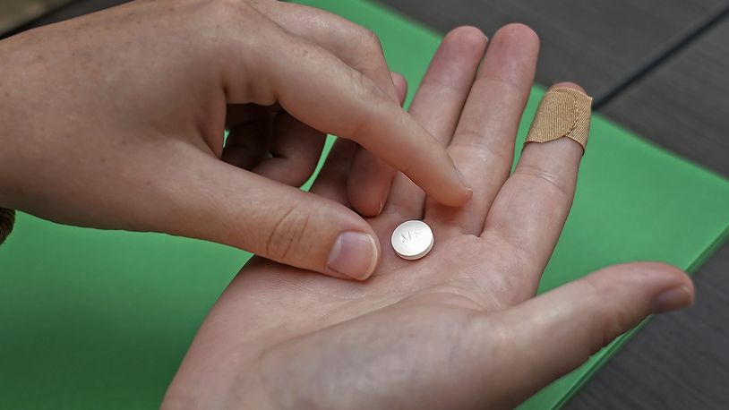 FILE - A patient prepares to take the first of two combination pills, mifepristone, for a medication abortion during a visit to a clinic in Kansas City, Kan., on, Oct. 12, 2022. (AP Photo/Charlie Riedel, File)