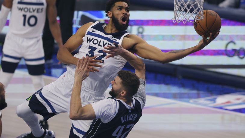 FILE - Minnesota Timberwolves center Karl-Anthony Towns (32) drives to the basket over Dallas Mavericks forward Maxi Kleber (42) during the second half in Game 4 of the NBA basketball Western Conference finals, Tuesday, May 28, 2024, in Dallas. (AP Photo/Gareth Patterson, File)