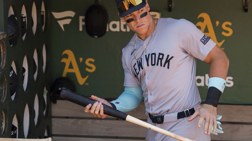 New York Yankees' Aaron Judge grabs a bat from the dugout before a baseball game against the Oakland Athletics in Oakland, Calif., Sunday, Sept. 22, 2024. (AP Photo/Nic Coury)