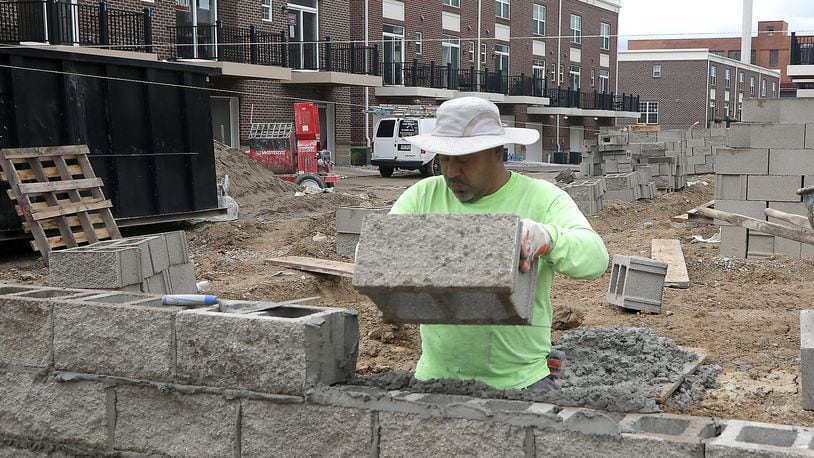 A construction crew works on the foundation for the final set of townhomes in the Center Street Townes project in downtown Springfield Tuesday, August 30, 2022. The county saw an estimated 1,000 more people employed last month when compared to previous trends. BILL LACKEY/STAFF