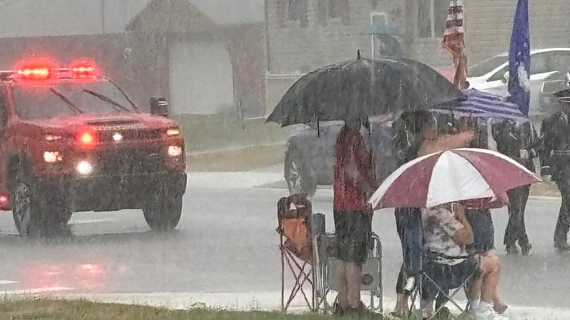 Spectators watch the  2024 Enon Independence Day Parade in the rain Thursday, July 4, 2024. Photo by Denise Bockleman.
