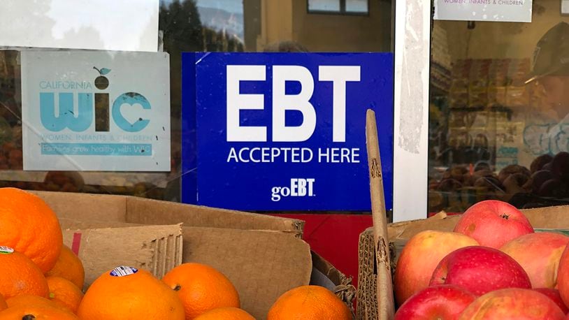 A sign noting the acceptance of electronic benefit transfer (EBT) cards that are used by state welfare departments to issue benefits is displayed at a grocery store on December 04, 2019, in Oakland, California. The Biden administration will end the COVID-19 emergency Supplemental Nutrition Assistance Program, or SNAP, allotments at the end of February. SNAP benefits return to normal beginning in March.  (Photo by Justin Sullivan/Getty Images)