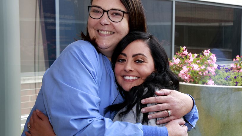 Amanda Donnelly, left, hugs Alaina Tuttle outside the Birthing Center at Springfield Regional Medical Center Thursday, August 8, 2024. Amanda was Alaina's nurse when she was a small girl battling cancer at Dayton Children's Hospital and now 20 years later Alaina is a nursing and they both work together at the Springfield hospital. BILL LACKEY/STAFF