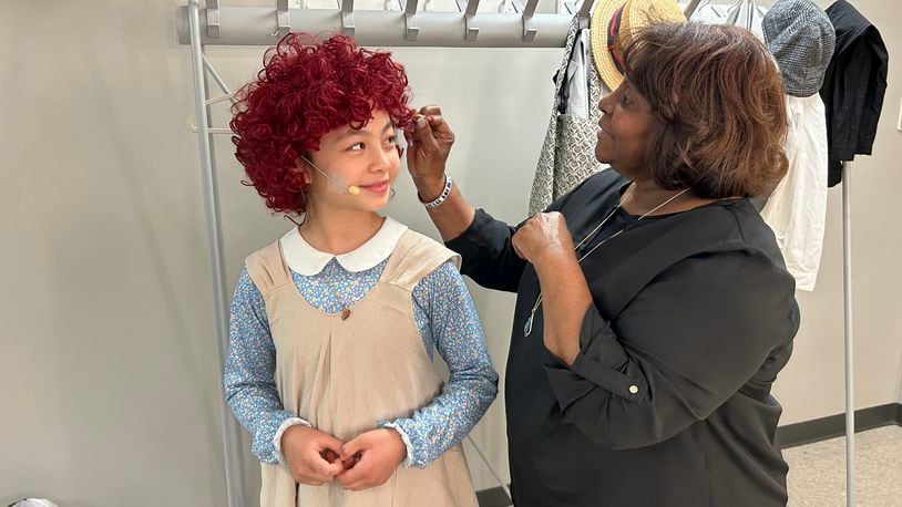 Director Monica Logan touches up Eve Choi, who plays the title character, prior to a dress rehearsal for Springfield Junior Civic Theatre's production of "Annie, Jr." that will be performed Thursday through Saturday to the John Legend Theater.