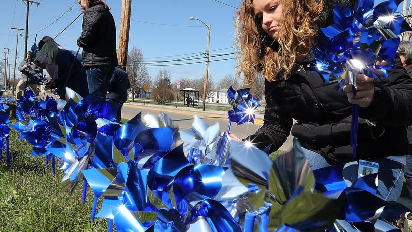 Natasha Foster, right, and other members of the Clark County Family & Children’s Services put out pinwheels in front of the Department of Jobs and Family Services building during the 2018 recognition of Child Abuse Prevention month, which occurs nationally every April. Bill Lackey/Staff