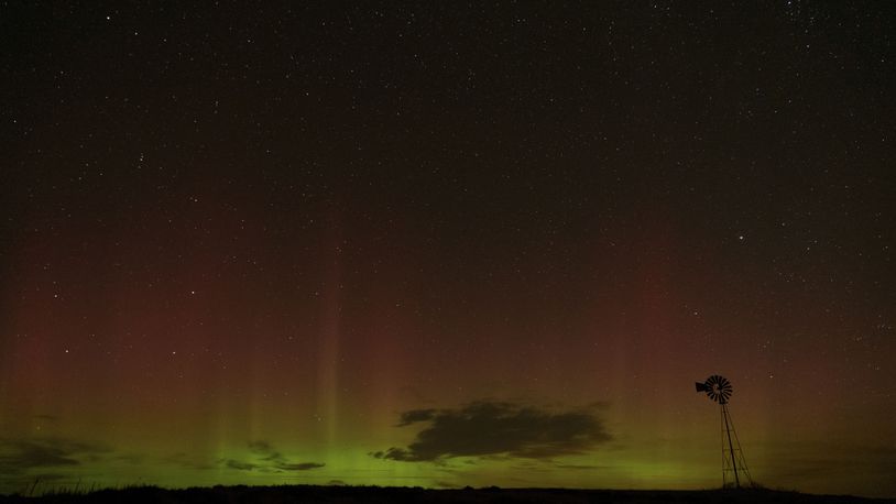 An aurora borealis, also known as the northern lights, is seen in the night sky behind a windmill water pump on Tuesday, Sept. 24, 2024, near Washtucna, Wash. (AP Photo/Ted S. Warren)