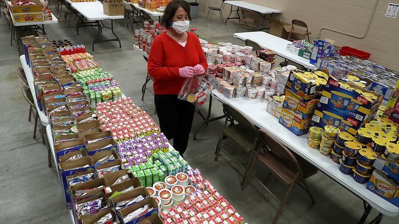 Tecumseh Schools Superintendent Paula Crew was working with other school staff and volunteers to fill food bags for students with the food that was donated by the community. BILL LACKEY/STAFF