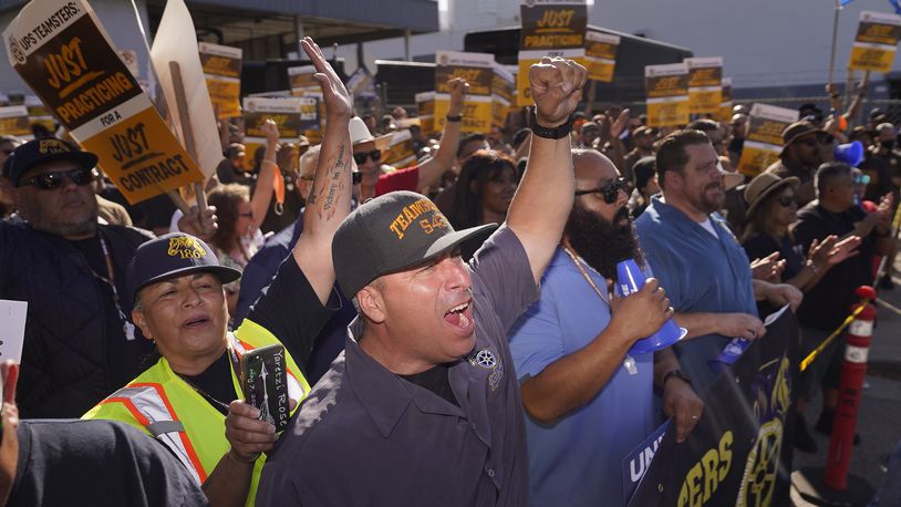 FILE - Teamsters and workers hold a rally in downtown Los Angeles, July 19, 2023, as a deadline neared in negotiations between the union and United Parcel Service. (AP Photo/Damian Dovarganes)