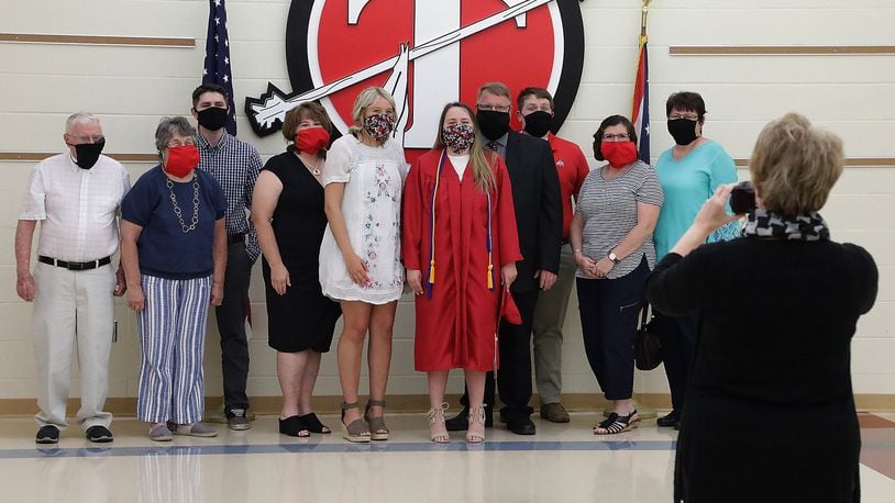 Tecumseh High School 2020 graduate Ellie Gehret, center, and her family pose for a picture with masks on during her individual graduation ceremony last year. BILL LACKEY/STAFF