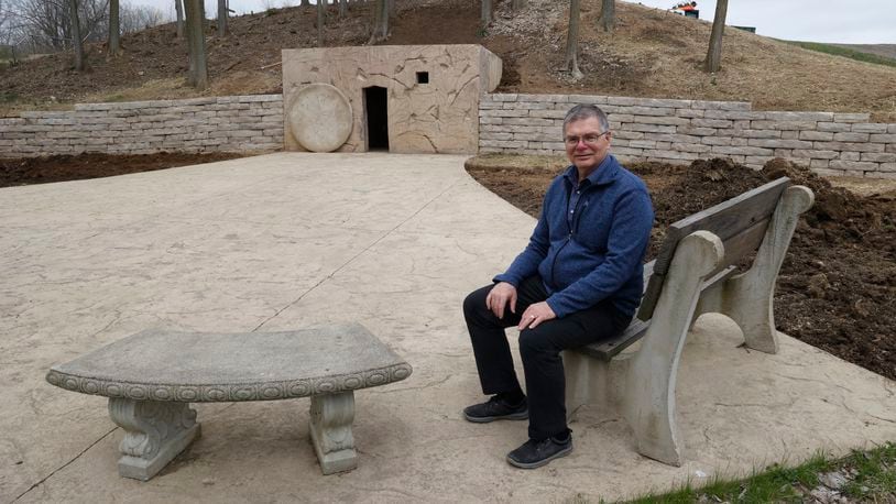 Pastor Brian Miller, of the Berea Bible Church, sits outside the Jesus tomb re-creation outside the church Tuesday, April 4, 2023. Berea Bible Church is developing the area around the tomb to make it a public park where people can come and enjoy the surroundings. BILL LACKEY/STAFF