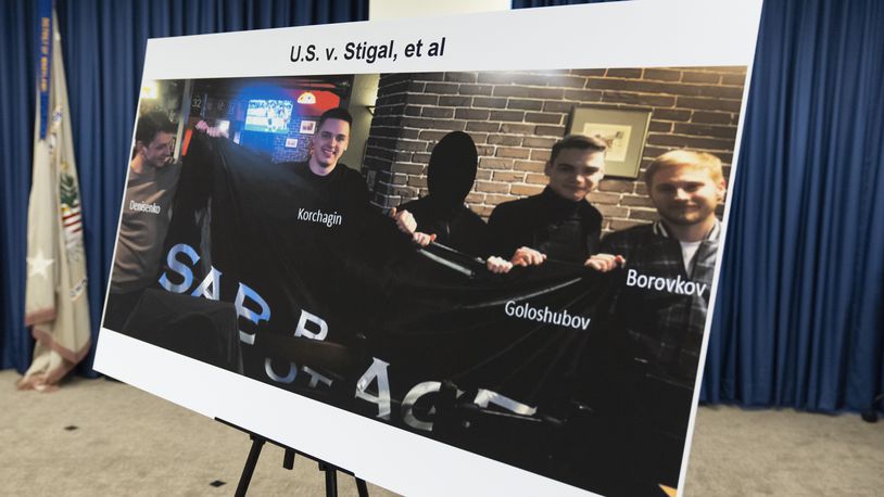 A photo of Russian suspects wanted by the FBI involved in a conspiracy to commit criminal cyber activities against Ukrainian government systems is displayed during a press conference at the Office of the United States Attorney in Baltimore, Thursday, Sept. 5, 2024. (AP Photo/Stephanie Scarbrough)