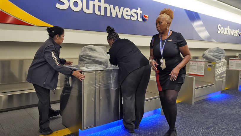 Southwest Airlines employees cover the ticket counters with plastic wrap just before Tampa International Airport was closing due to the possible arrival of Hurricane Milton Tuesday, Oct. 8, 2024, in Tampa, Fla. (AP Photo/Chris O'Meara)