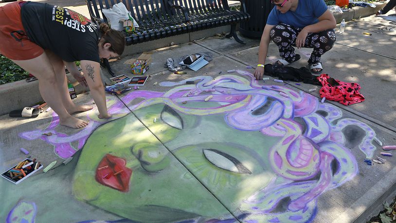 Journey Armstrong and Charlie Scott work on their chalk art Saturday, Oct. 5, 2024 during ChalkFest at National Road Commons Park in downtown Springfield. Dozens of amateur and professional artists from around the area showed off their skill on the sidewalks and streets around the park. ChalkFest also featured live music, food trucks and creative activities for the kids. BILL LACKEY/STAFF