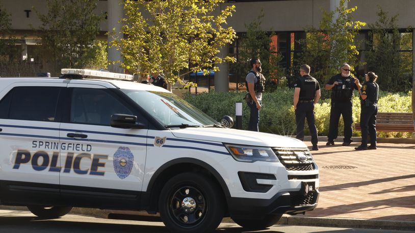 Springfield and Dayton police officers outside the City Hall building following an evacuation due to a threat Thursday. BILL LACKEY/STAFF