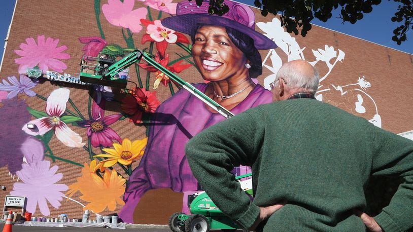 People gather around the mural of Springfield civil rights advocate Hattie Moseley during a dedication ceremony Tuesday, Oct. 11, 2022. BILL LACKEY/STAFF