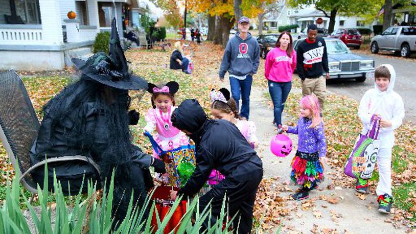 Trick-or-treaters get candy. GREG LYNCH / STAFF