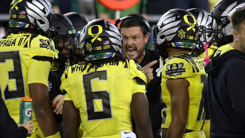 Oregon head coach Dan Lanning, center, talks to his players during a timeout in the first half of an NCAA college football game against Michigan State, Friday, Oct. 4, 2024, in Eugene, Ore. (AP Photo/Amanda Loman)