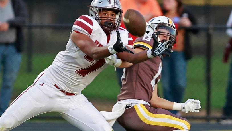 Urbana's Julian Davis catches a touchdown pass under pressure from Kenton Ridge's Bryndyn Parsons.  BILL LACKEY/STAFF