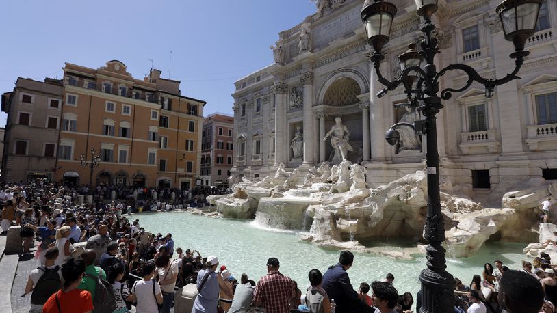 FILE - Tourists admire the Trevi Fountain in Rome, June 7, 2017. (AP Photo/Gregorio Borgia, File)