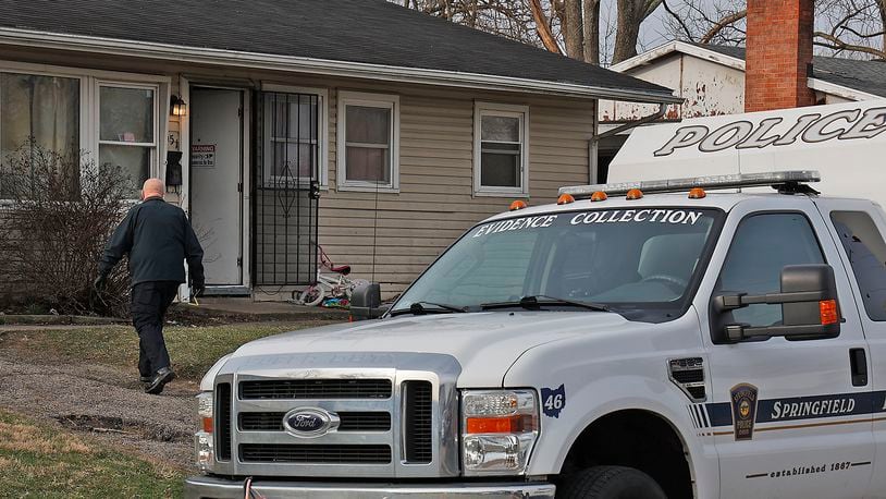 A Springfield police officer enters a house in the 500 block of Mead Lane on March 8, 2023, as officers investigate an overnight shooting at the location. BILL LACKEY/STAFF