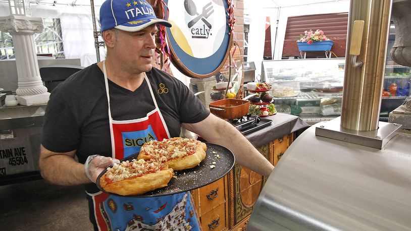 Tom Thompson, owner of Eatly, puts two fig, bacon, onion and gorgonzola fried pizzas in the pizza oven to bake for a few minutes Thursday, May 23, 2024. BILL LACKEY/STAFF