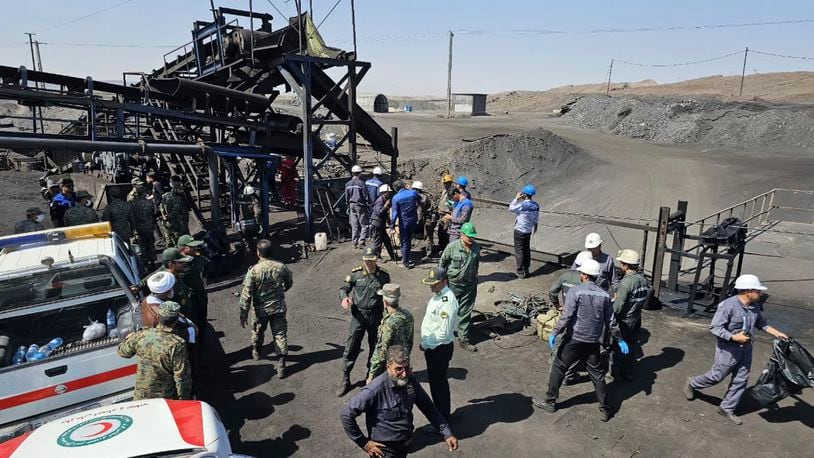 In this photo released by Iranian Red Crescent Society, miners and police officers are seen at the site of a coal mine where methane leak sparked an explosion on Saturday, in Tabas, some 540 kilometers (335 miles) southeastern of the capital, Tehran, Iran, Sunday, Sept. 22, 2024. (Iranian Red Crescent Society, via AP)