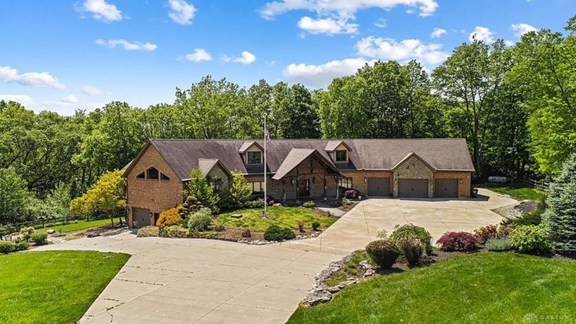 The front of the home has a three car attached garage on the main level and an additional two car on the basement level. It has a covered entry with wood beams and an extended driveway with heavy landscaping including a waterfall.