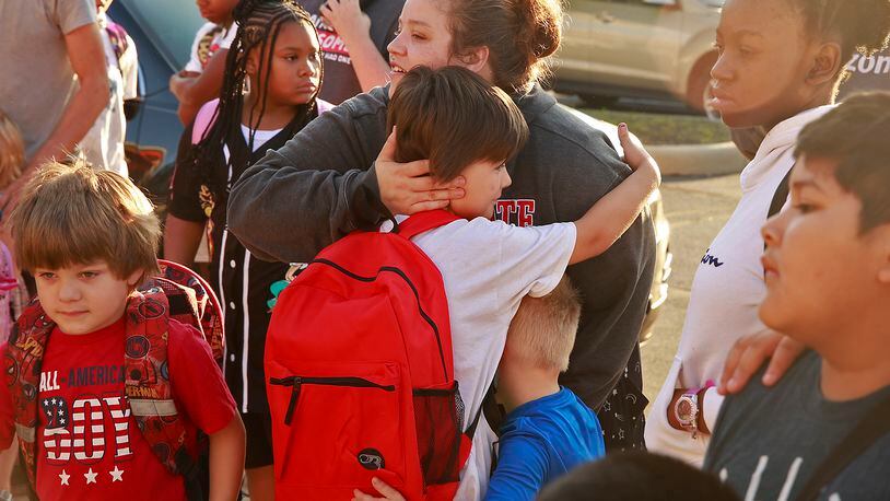 Aiden Watts gets a hug from his mom, Caitlin Richards, and his little brother before going in to Fulton Elementary on the first day of school Wednesday, August 14, 2024. BILL LACKEY/STAFF