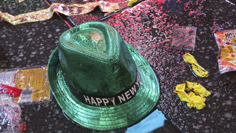 FILE - In this Jan. 1, 2019, file photo a "Happy New Year" hat lies on the wet ground along with other items following the celebration in New York's Times Square. Setting a New Year’s resolution about improving your finances is an excellent way to start 2021. But before you come up with a list of goals, be aware that there are a few you should avoid.  (AP Photo/Tina Fineberg, File)