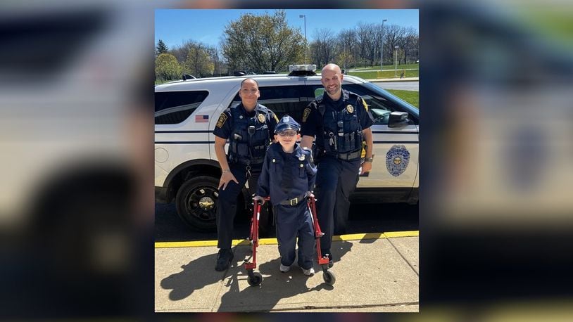 Officer Amanda Jackson (left) and Officer Adam Schaefer (right), two School Resource Officers for the Springfield City School District, “answered the call of duty” to provide Fulton Elementary School student Jonathan Beale with an honorary “SPD Police Officer” experience. Contributed