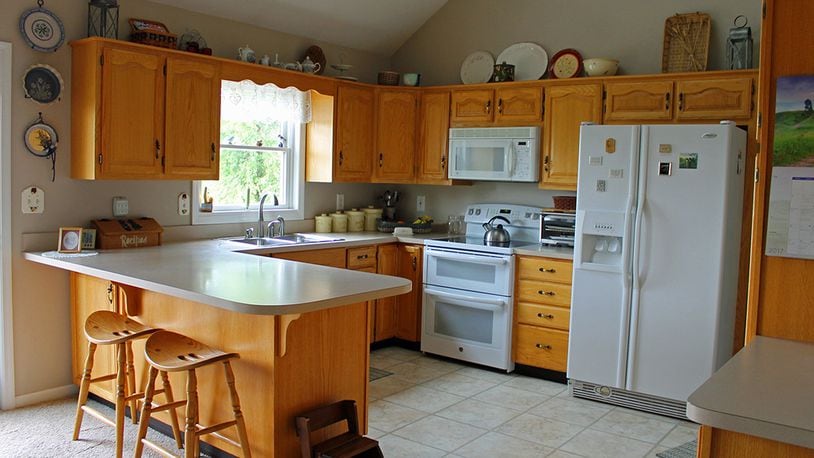 The kitchen includes a breakfast bar and plenty of counter space. French doors open to the backyard and rear deck.